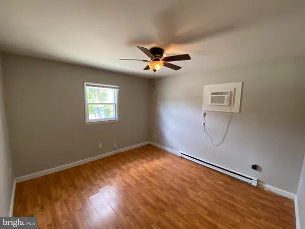 a view of a big room with wooden floor and a chandelier fan