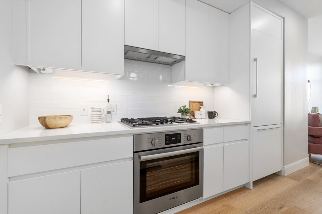 191 Washington Street, Unit 720 Boston, MA 02135 - Photo 6 of 29 a kitchen with stainless steel appliances granite countertop a stove and a white cabinets