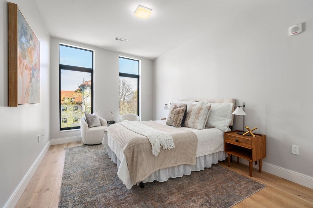 191 Washington Street, Unit 720 Boston, MA 02135 - Photo 8 of 29 a bedroom with a bed and wooden floor