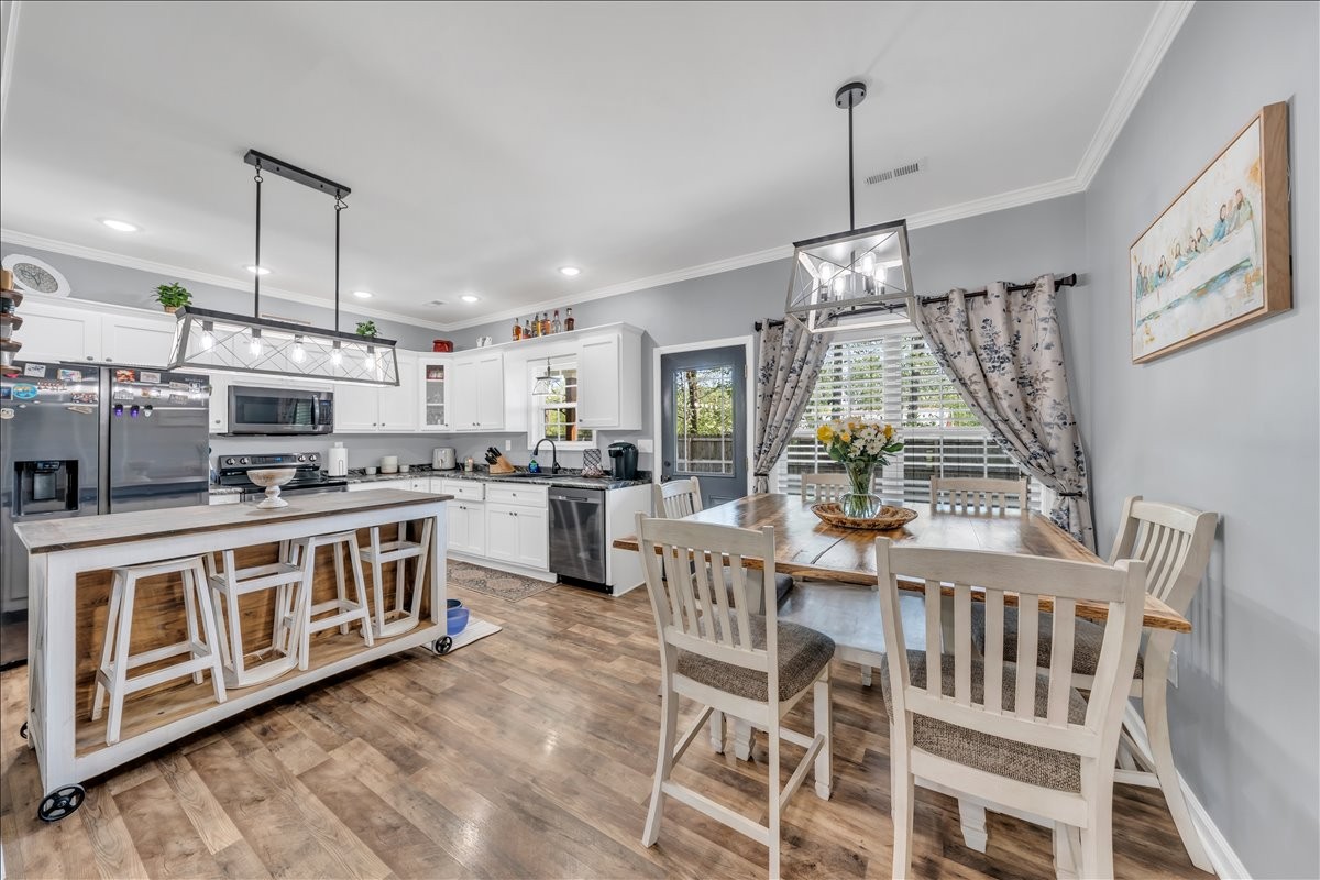 8 Valley Pond Lane Kelso, TN 37348 - Photo 14 of 75 a kitchen with stainless steel appliances granite countertop a stove top oven a sink dishwasher a dining table and chairs with wooden floor