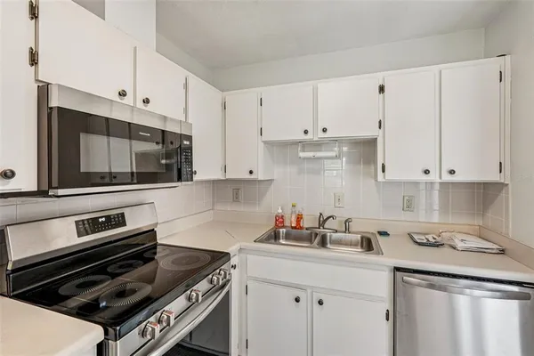 a kitchen with cabinets and steel appliances