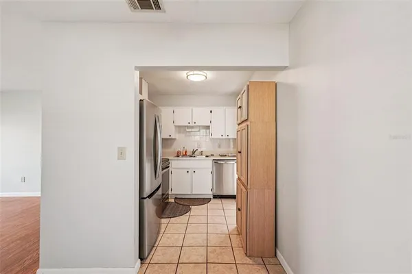 a kitchen with a refrigerator and white cabinets