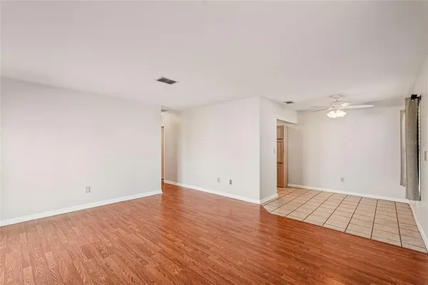 a view of an empty room with wooden floor