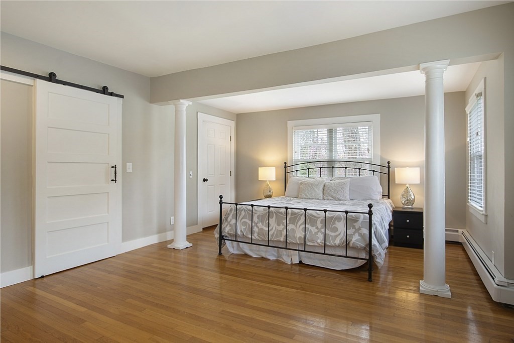 97 Argilla Road Andover, MA 01810 - Photo 16 of 42 a spacious bedroom with a bed and wooden floor