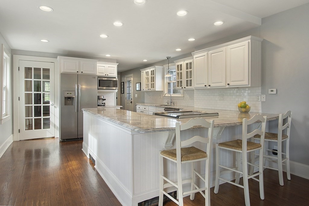 97 Argilla Road Andover, MA 01810 - Photo 10 of 42 a kitchen with stainless steel appliances granite countertop a stove top oven a refrigerator and white cabinets with wooden floor