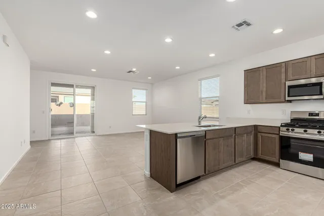 a large kitchen with stainless steel appliances granite countertop a stove and a sink