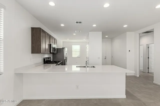 a large kitchen with kitchen island a sink stainless steel appliances and cabinets