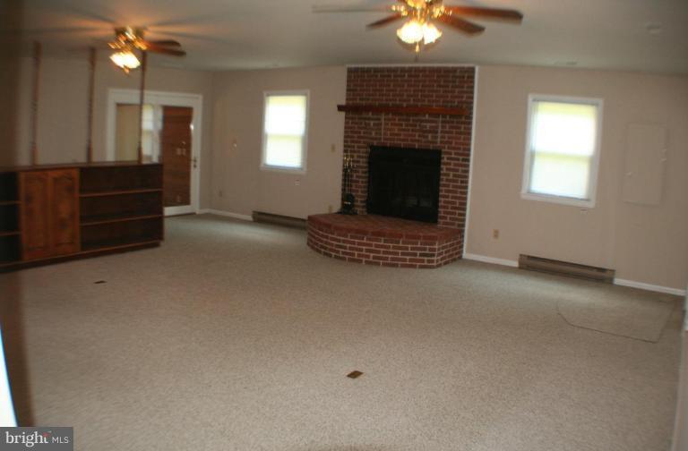 304 Warfieldsburg Road Westminster, MD 21157 - Photo 5 of 19 wooden floor fireplace and windows in an empty room