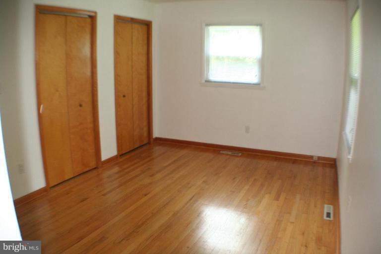 304 Warfieldsburg Road Westminster, MD 21157 - Photo 10 of 19 an empty room with wooden floor and windows