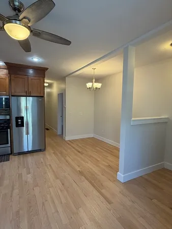 a view of a room with wooden floor and a ceiling fan