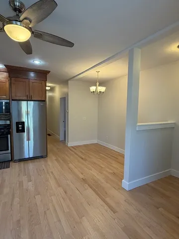 a view of a room with wooden floor and a ceiling fan