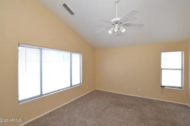 an empty room with windows and fan