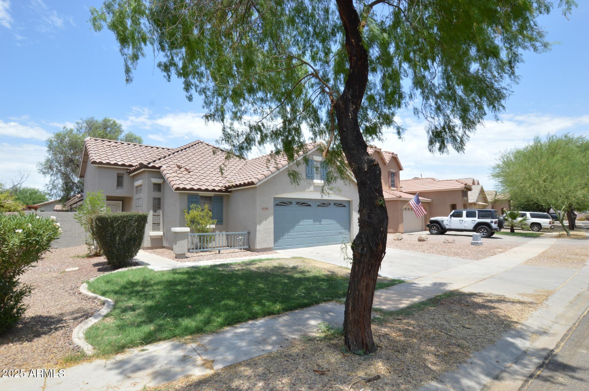 4094 East Rustler Way Gilbert, AZ 85297 - Photo 2 of 34 a front view of a house with garden and trees