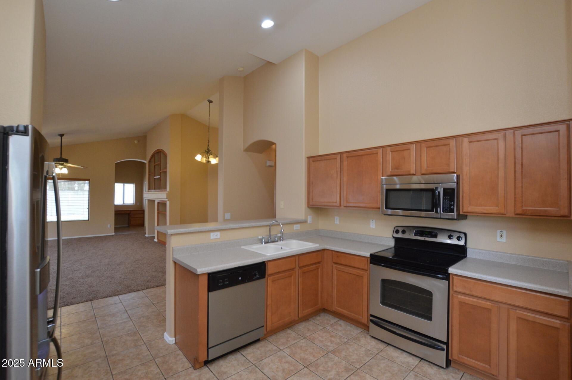 4094 East Rustler Way Gilbert, AZ 85297 - Photo 5 of 34 a kitchen with stainless steel appliances granite countertop a stove and a sink