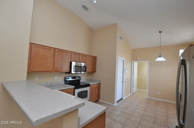 a kitchen with a sink a counter top space cabinets and stainless steel appliances