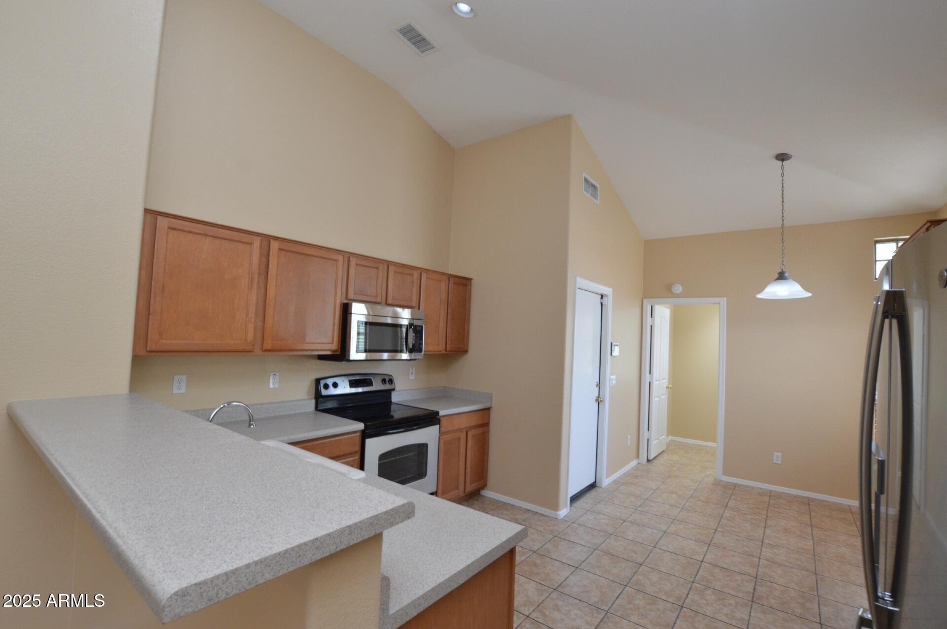 4094 East Rustler Way Gilbert, AZ 85297 - Photo 6 of 34 a kitchen with a sink a counter top space cabinets and stainless steel appliances