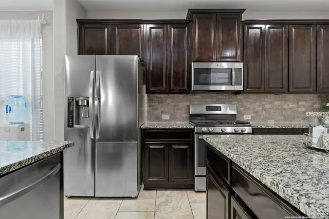 a kitchen with granite countertop stainless steel appliances and wooden cabinets