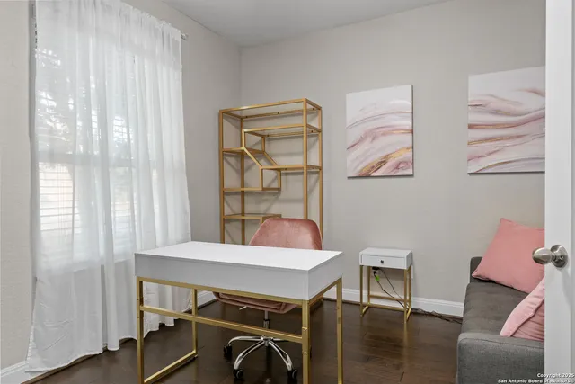 a view of a workspace with furniture and a window