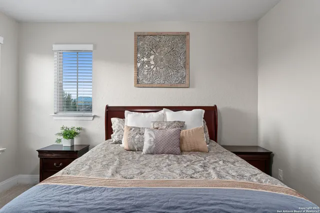 a large bed sitting in a bedroom next to a window