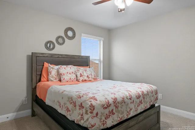 a bedroom with a bed and a lamp on dresser