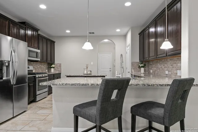 a kitchen with granite countertop cabinets and refrigerator