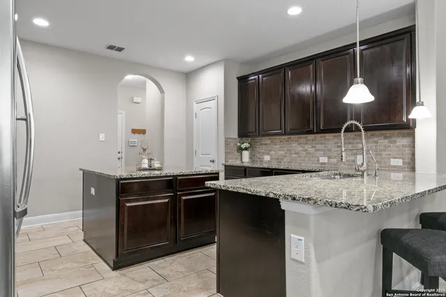 a kitchen with stainless steel appliances granite countertop a sink and a stove