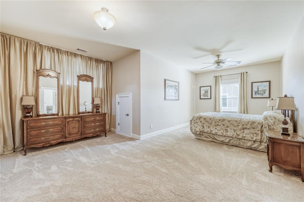 2380 Muskogee Lane Braselton, GA 30517 - Photo 23 of 30 a spacious bedroom with a bed and a chandelier
