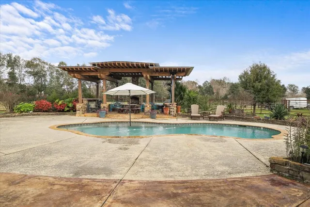 a view of a swimming pool with a patio and a yard