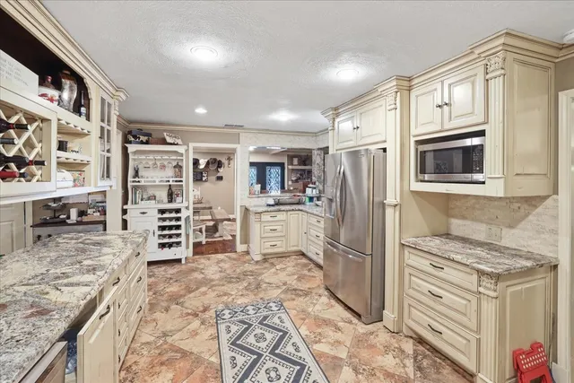 a kitchen with stainless steel appliances granite countertop a refrigerator and a stove top oven