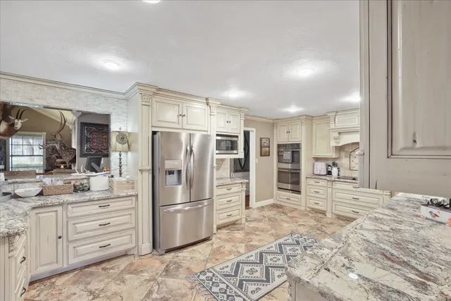 a kitchen with stainless steel appliances kitchen island granite countertop a refrigerator and cabinets