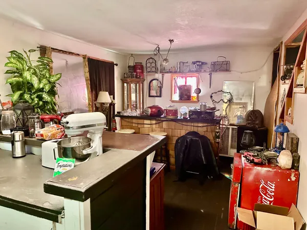a utility room with lots of clutter and furniture
