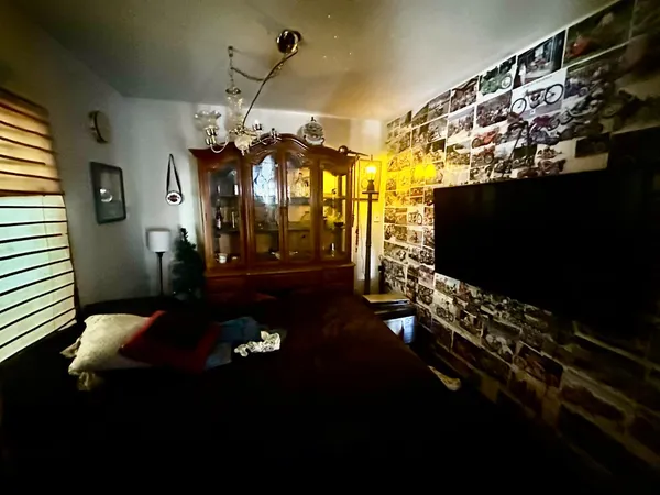 a living room with patio furniture and a flat screen tv