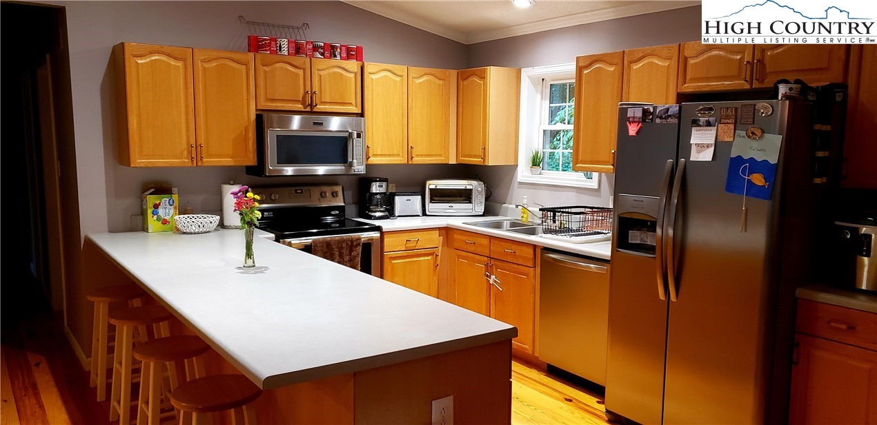 173 Country Road Deep Gap, NC 28618 - Photo 4 of 5 a kitchen with stainless steel appliances granite countertop a refrigerator a oven a sink dishwasher and wooden cabinets