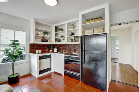 a kitchen with stainless steel appliances a refrigerator and a potted plant