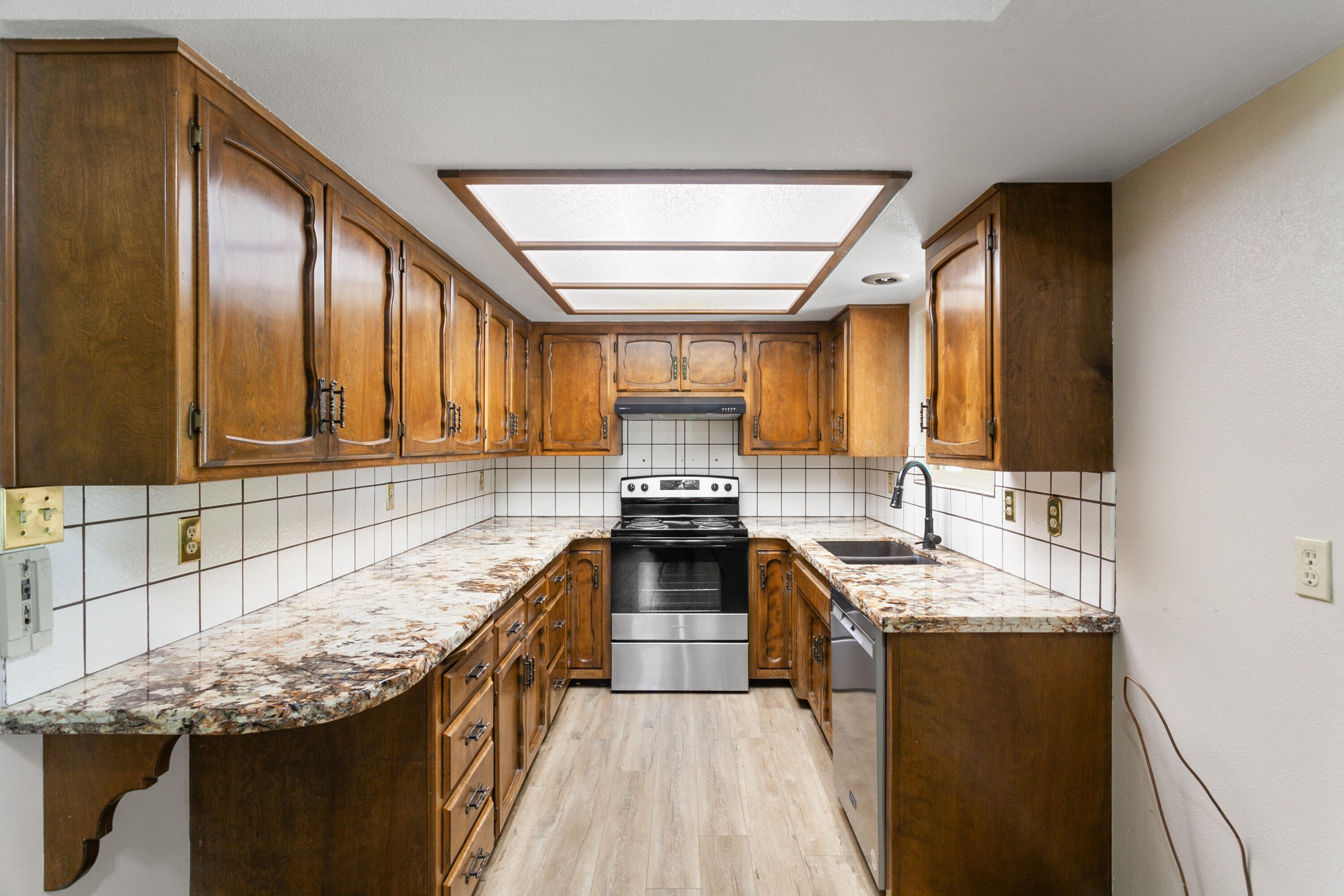 5858 Deschutes Road Anderson, CA 96007 - Photo 11 of 30 a kitchen with stainless steel appliances granite countertop wooden cabinets and a stove top oven