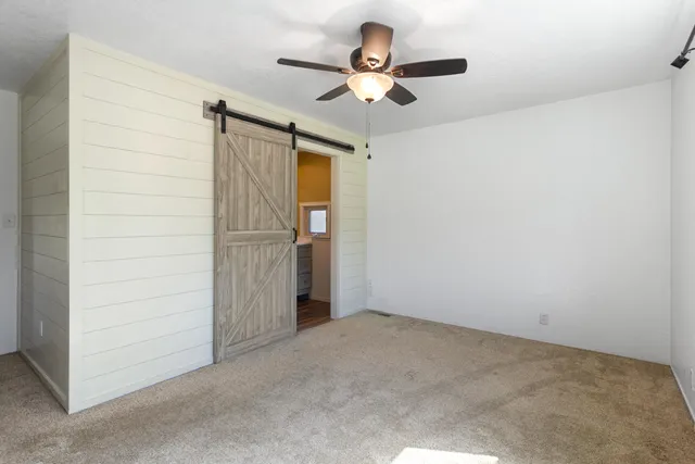 en empty room with closet and ceiling fan