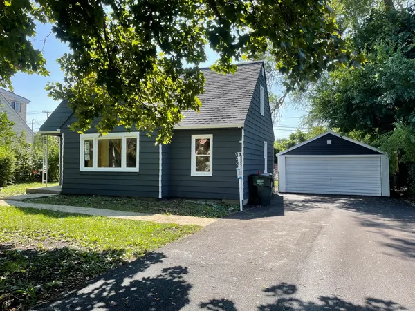 a view of a house with a yard and large tree