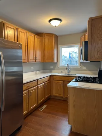 a kitchen with granite countertop cabinets stainless steel appliances a sink and a window