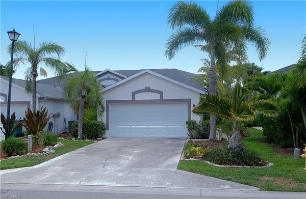 a front view of a house with a yard and a garage