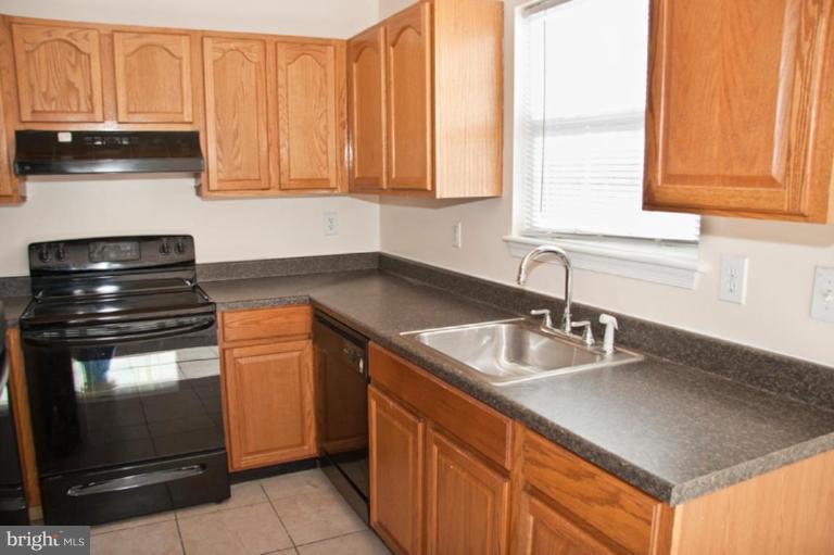3515 Corn Stream Road Randallstown, MD 21133 - Photo 12 of 23 a kitchen with granite countertop a sink stove and cabinets