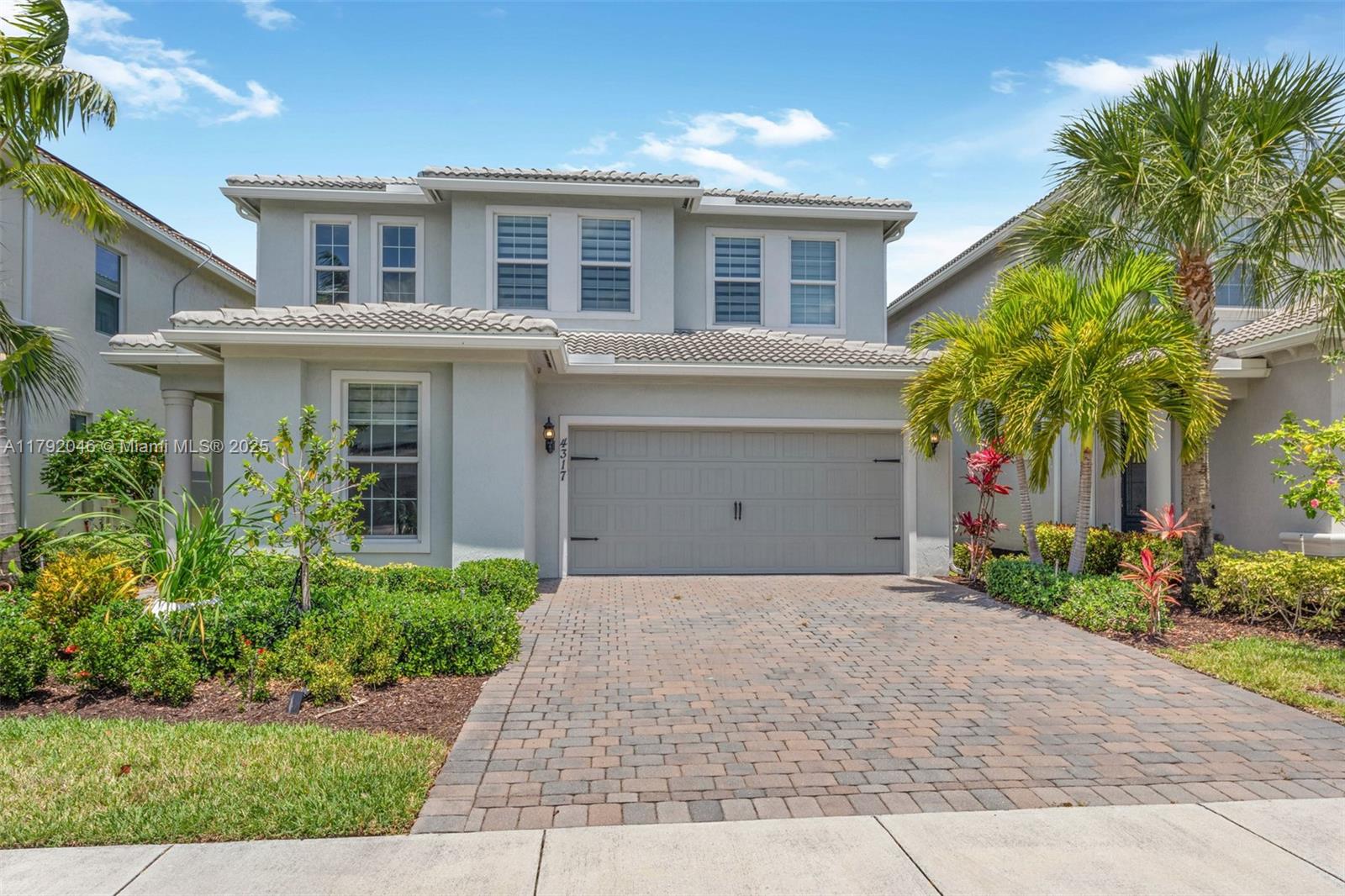 a front view of a house with a yard and palm trees
