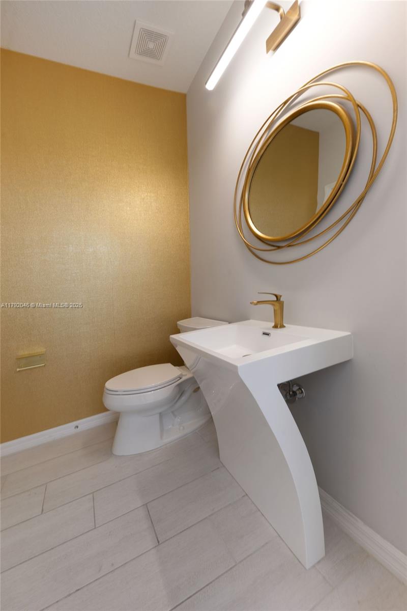 4317 Ficus Street Hollywood, FL 33021 - Photo 7 of 29 a bathroom with a sink a toilet and a mirror