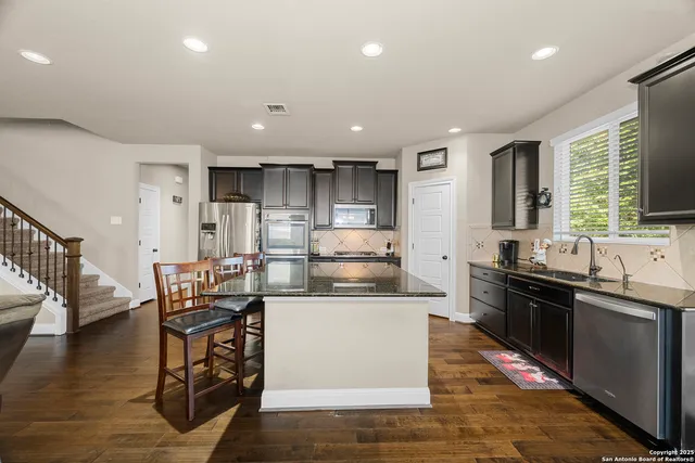a dining room with furniture a chandelier and wooden floor