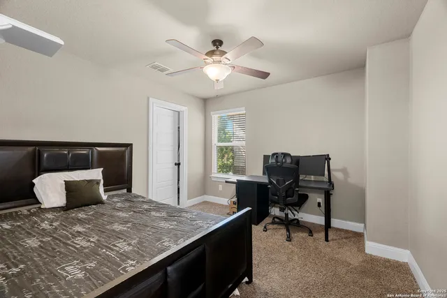 a bedroom with a bed and a ceiling fan