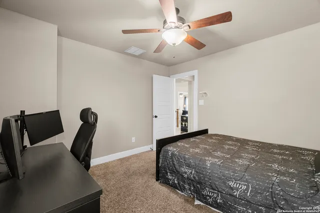 a living room with furniture and a ceiling fan