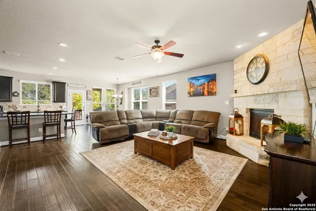 a living room with furniture kitchen view and a wooden floor