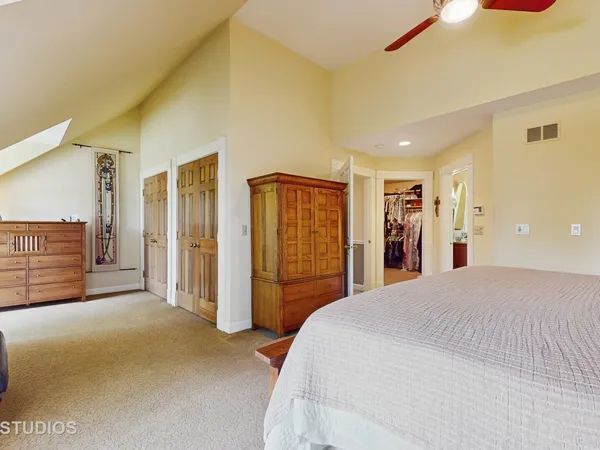 a spacious bedroom with a bed and a walk in closet