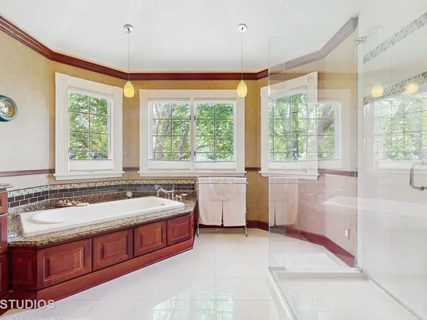 a spacious bathroom with sink and mirror with bathtub