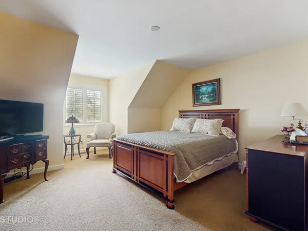 a bedroom with a bed and a flat tv screen on the dresser