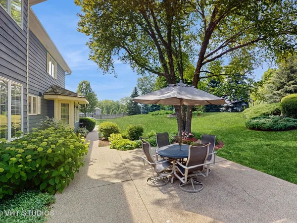 a view of a patio with a table and chairs under an umbrella